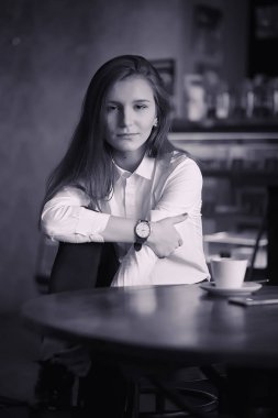 Bir kız bir kafede kahve içiyor. Bir kadın kahvaltı yapıyor