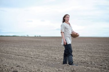 Genç bir köylü tahıl alanıyla sows