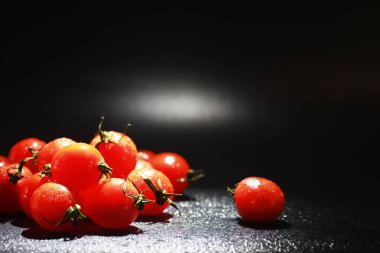Sprey siyah bir arka plan üzerinde Kiraz domates