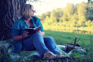 kadın yatıyordu ve kitap Güneş okuyun