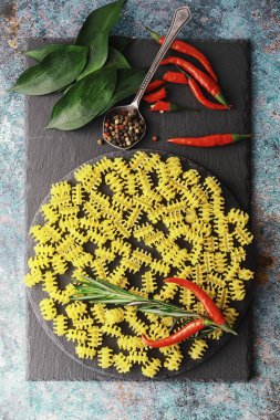 Taş zeminde pişmemiş makarna. Baharat ve baharatlarla