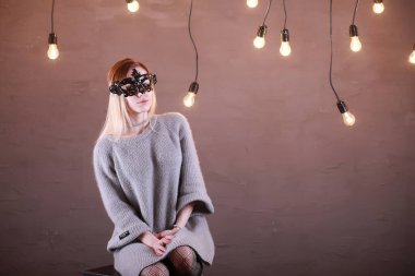 Siyah bir maske içinde sarı saçlı bir kızla