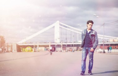 Genç bir adam öğle yemeği zamanında parkta yürür. Bir adam yürüyüşe çıktı. 