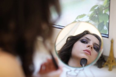 Güzel kız makyaj yapıyor.