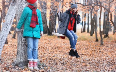 Kız sonbahar şehir parkında yaprak düşer. Genç güzel wi anne