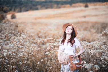 Doğada hamile bir kadın sonbaharda yürüyüşe çıkıyor.