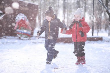 Çocuklar parkta ilk kar yürümek