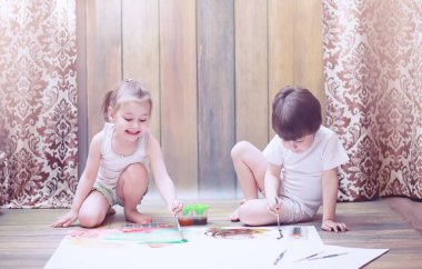 Küçük çocuklar büyük bir kağıda boya