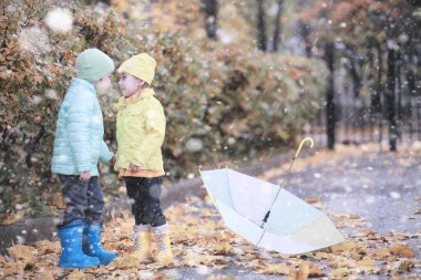 Çocuklar parkta ilk kar yürümek