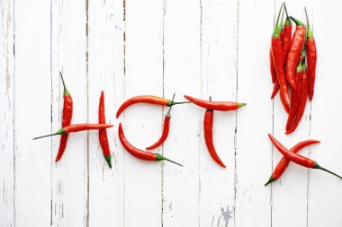 Beyaz ahşap bir arka planda acı kırmızı biber.