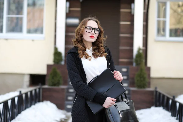 Geschäftsfrau in strenger Kleidung vor dem Hintergrund von Gebäuden — Stockfoto