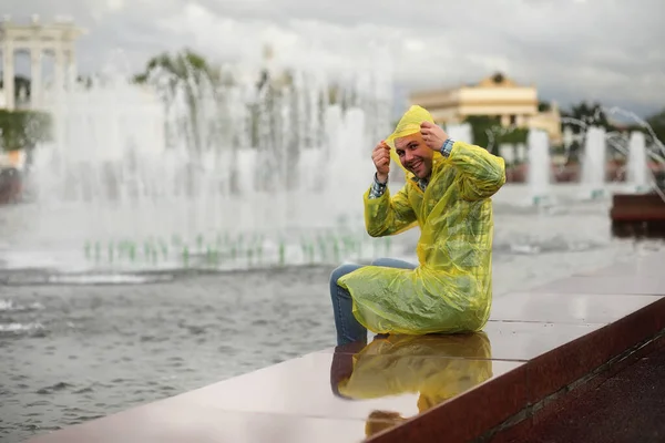 A man in a raincoat on a rainy day