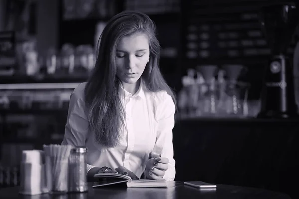 Een meisje in een café drinkt koffie. Een vrouw is ontbijten — Stockfoto