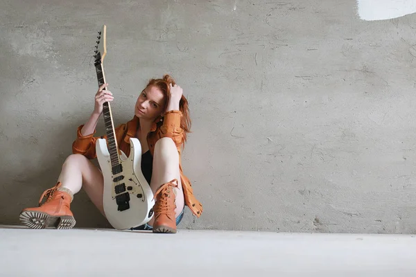 Menina ruiva jovem com uma guitarra elétrica. Músico de rock gir — Fotografia de Stock