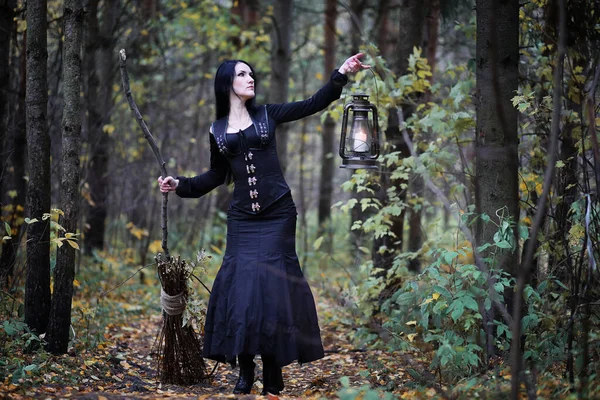 Une femme en costume de sorcière dans une forêt — Photo