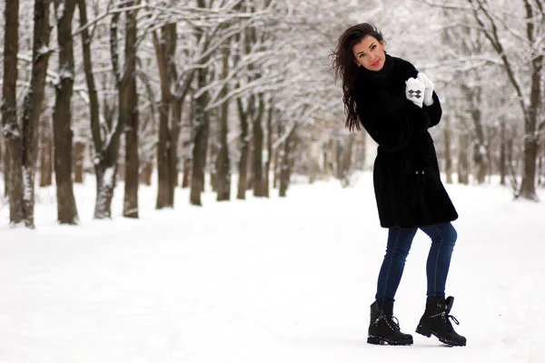 A young couple walk in a winter park — Stock Photo, Image