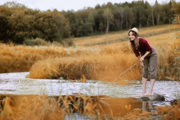 Ragazza in autunno con una canna da pesca — Foto Stock