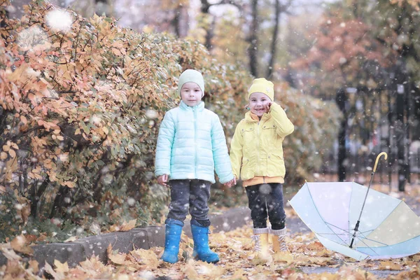 Çocuklar parkta ilk kar yürümek — Stok fotoğraf