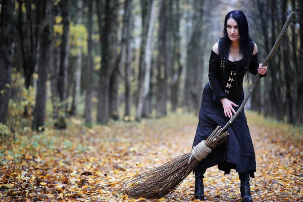 A woman in a witch suit in a forest — Stock Photo, Image