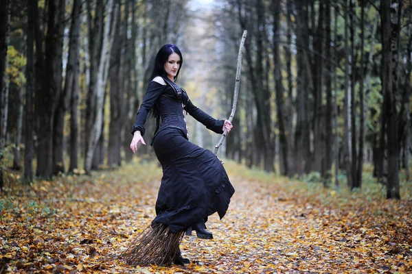 Une femme en costume de sorcière dans une forêt — Photo