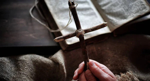 Livro velho religioso em uma mesa de madeira. Uma cruz religiosa amarrado sagacidade — Fotografia de Stock