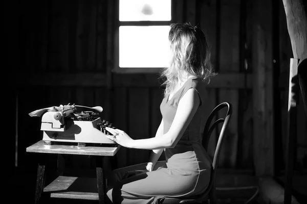 Una chica imprime en una vieja máquina de escribir — Foto de Stock