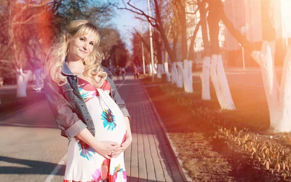 Menina grávida em um passeio no parque. Menina com uma barriga na ci — Fotografia de Stock