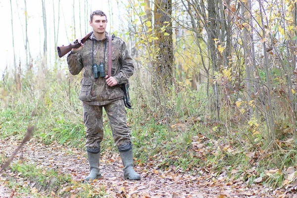 Ο άνθρωπος στο καμουφλάζ και με τα πυροβόλα όπλα σε ένα δάσος ζώνη σε μια άνοιξη hun — Φωτογραφία Αρχείου