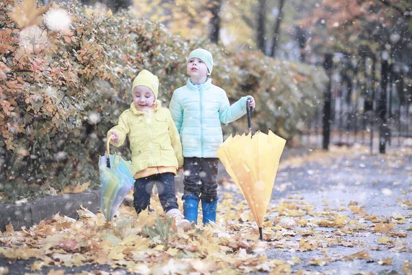 Les enfants marchent dans le parc première neige — Photo