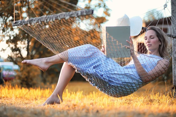 Mooi meisje in hangmat lezen van een boek — Stockfoto