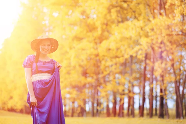 Joven chica hermosa en vestidos de la naturaleza. Una chica con sombrero camina — Foto de Stock