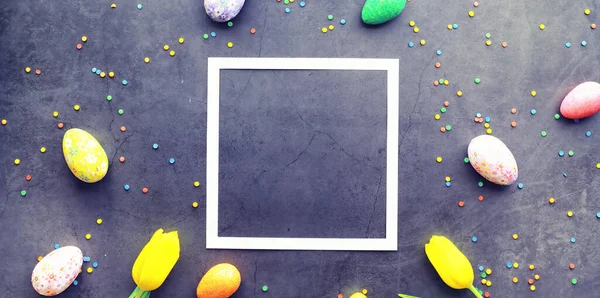 Pasen achtergrond op zwarte steen. Meerkleurige eieren en zoete eieren. — Stockfoto