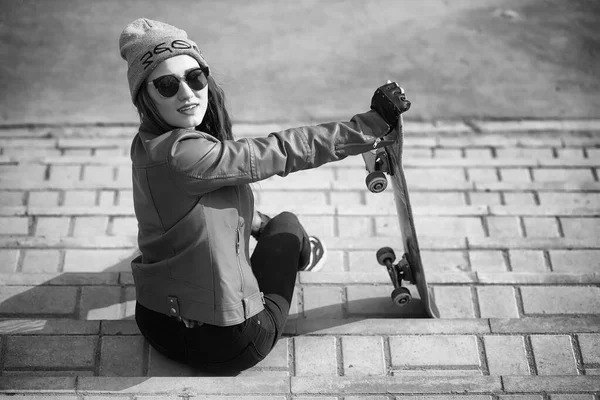 A young hipster girl is riding a skateboard. Girls girlfriends f — Stock Photo, Image