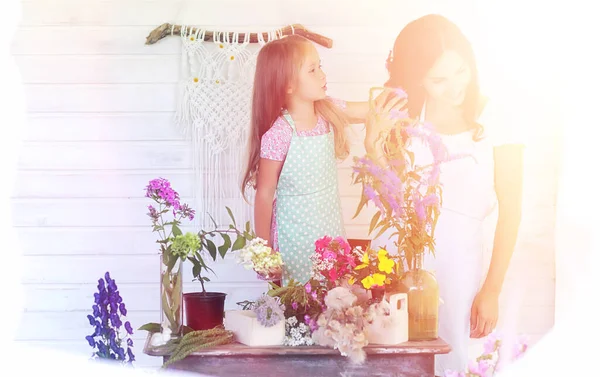 A young girl with a daughter is picking up a bouquet. A young mo — Stock Photo, Image