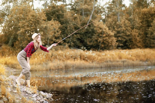 Girl in autumn with a fishing rod — Stock Photo, Image