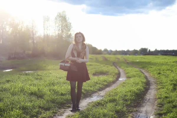 Una ragazza con un cappello mentre passeggia nel parco. Una ragazza con un cesto a piedi — Foto Stock