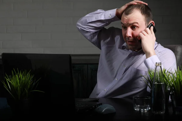 Uomo seduto a tavola e al lavoro sul computer portatile — Foto Stock