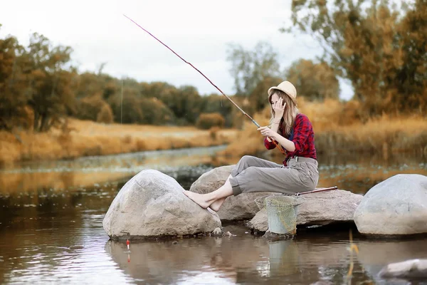 Flicka i höst med ett fiskespö — Stockfoto