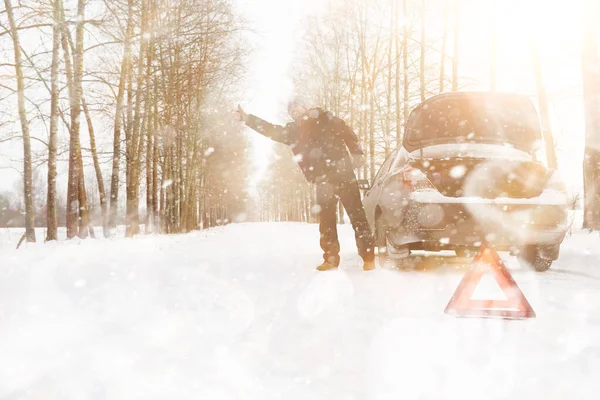 Mann und Auto. Winterspaziergang und Autoreparatur. — Stockfoto