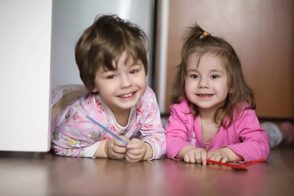 Gyerekek, fiúk és lányok mászkálnak a földön. A gyerekek nagyon... — Stock Fotó