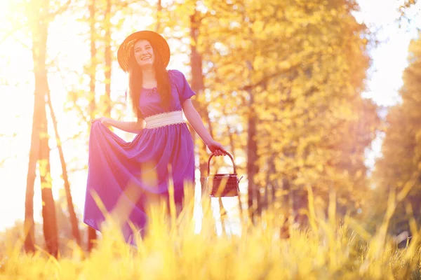 Молодая красивая девушка в платьях на природе. Девушка в шляпе ходит — стоковое фото