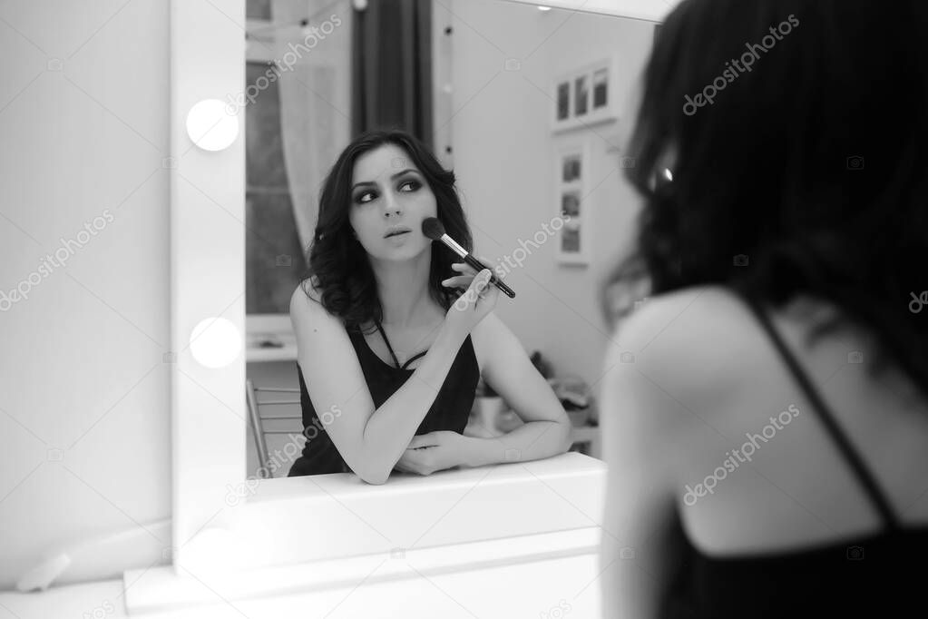 Girl doing makeup black and white