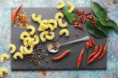 Taş zeminde pişmemiş makarna. Baharat ve baharatlarla