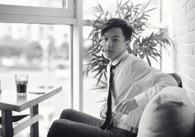 Genç Asyalı işadamı bir kafede bir ortak için bekliyor. Bu