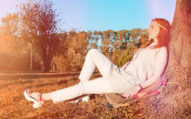 Bir parkta yürümek bir kız. Bahar Kızıl saçlı kız 