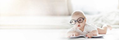 Yeni doğmuş bir bebek yumuşak bir yatakta gözlüklerle yatıyor..