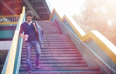 Genç bir adam öğle yemeği zamanında parkta yürür. Bir adam yürüyüşe çıktı. 