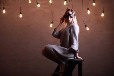 Siyah bir maske içinde sarı saçlı bir kızla