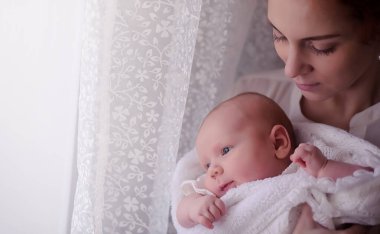 Anne kucağında yeni doğmuş bir bebekle. Kızın kucağında bir bebek var. 