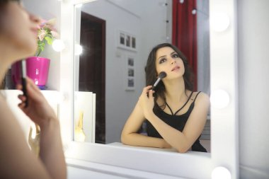 Güzel kız makyaj yapıyor.